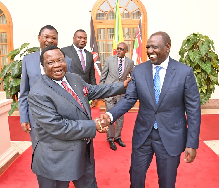 Francis Atwoli shakes hands with William Ruto after meeting in state house